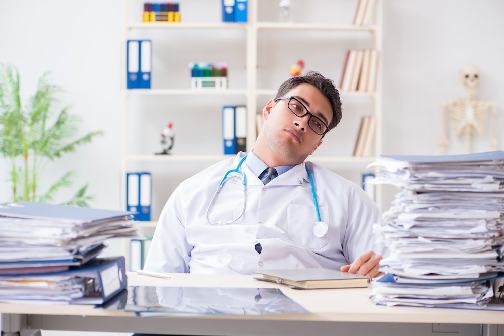 Busy doctor with too much work in hospital; blog: Why Outsourcing Medical Billing Services Might NOT Be Right for You